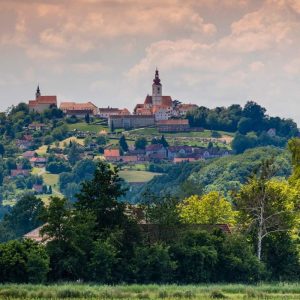 Veduta dalla pianura del paesino di Straden in Vulkanland Steiermark, con il campanile a cipolla sulla collina vulcanica